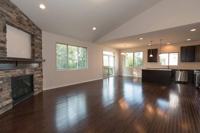 unfurnished living room with dark wood-style flooring, a fireplace, recessed lighting, an inviting chandelier, and baseboards