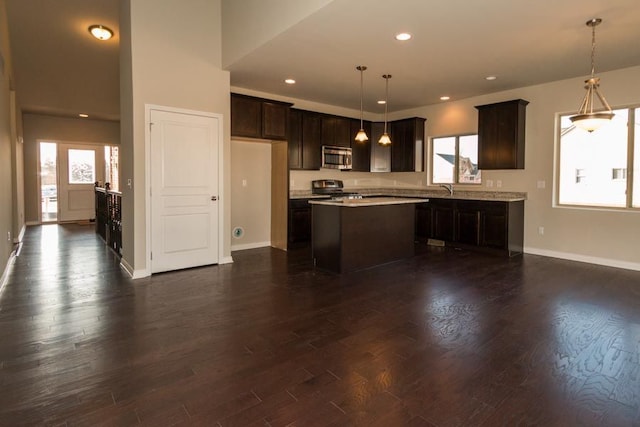 kitchen featuring dark wood-type flooring, stainless steel microwave, range, and dark brown cabinetry