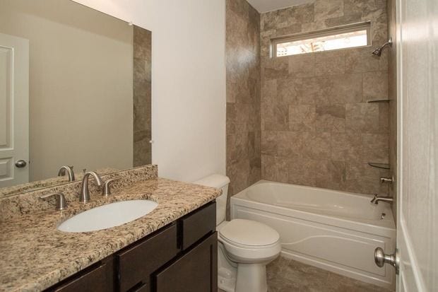 full bathroom with  shower combination, vanity, and toilet