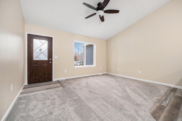 foyer entrance with ceiling fan, carpet flooring, and vaulted ceiling