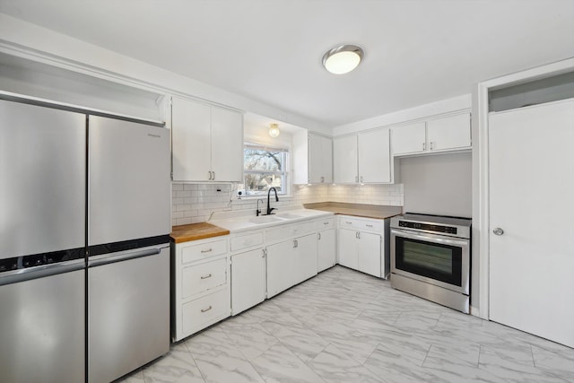 kitchen featuring tasteful backsplash, white cabinetry, appliances with stainless steel finishes, and sink