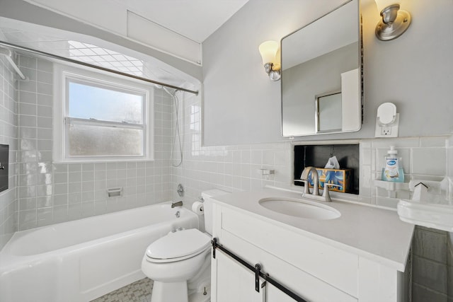 full bathroom with vanity, toilet, tiled shower / bath combo, and tile walls