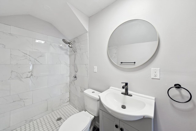 bathroom featuring vanity, lofted ceiling, toilet, and tiled shower