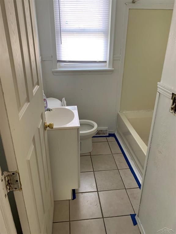 bathroom with vanity, tile patterned floors, a bathing tub, and toilet