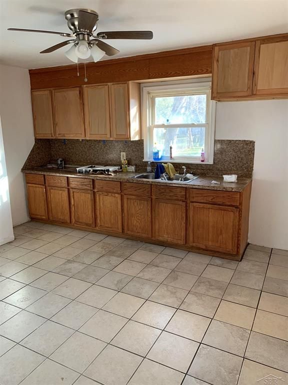 kitchen featuring sink, light tile patterned floors, backsplash, and ceiling fan