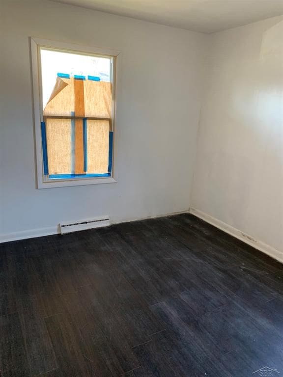 spare room featuring dark hardwood / wood-style floors and baseboard heating