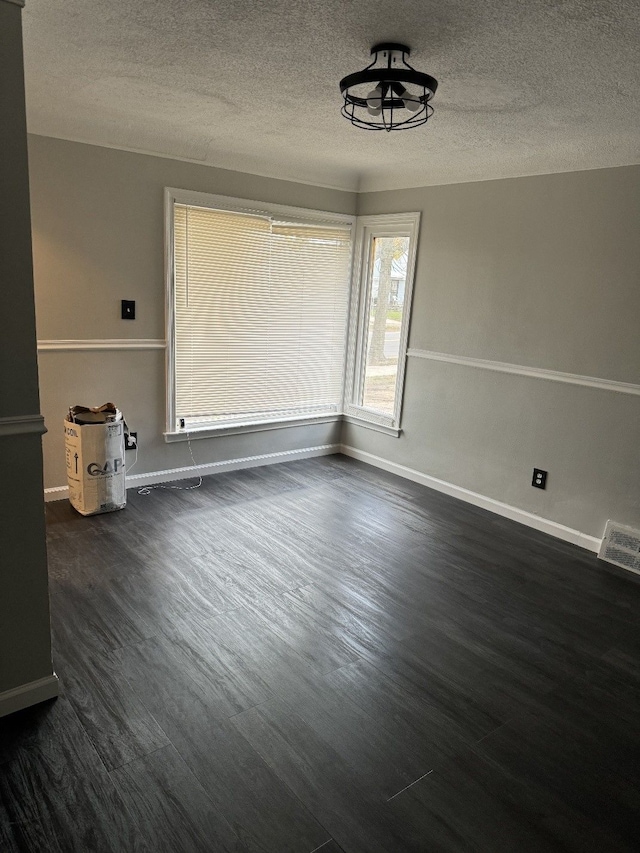 unfurnished room featuring dark hardwood / wood-style floors and a textured ceiling