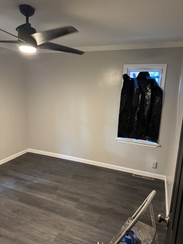 unfurnished room with dark wood-type flooring, ornamental molding, and ceiling fan