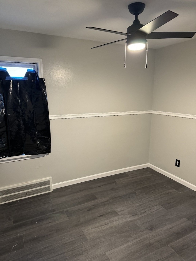 spare room featuring dark wood-type flooring and ceiling fan