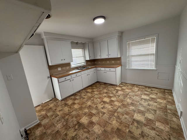 kitchen with white cabinetry, sink, and tasteful backsplash