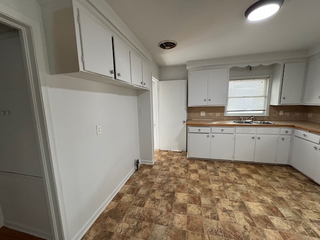 kitchen featuring white cabinetry, sink, and decorative backsplash