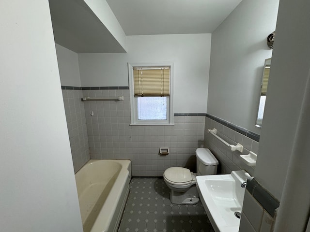 bathroom featuring a bath, tile walls, and toilet