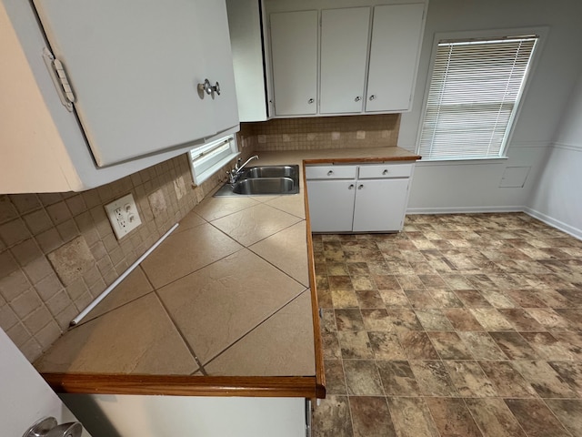 kitchen with white cabinetry, sink, and decorative backsplash