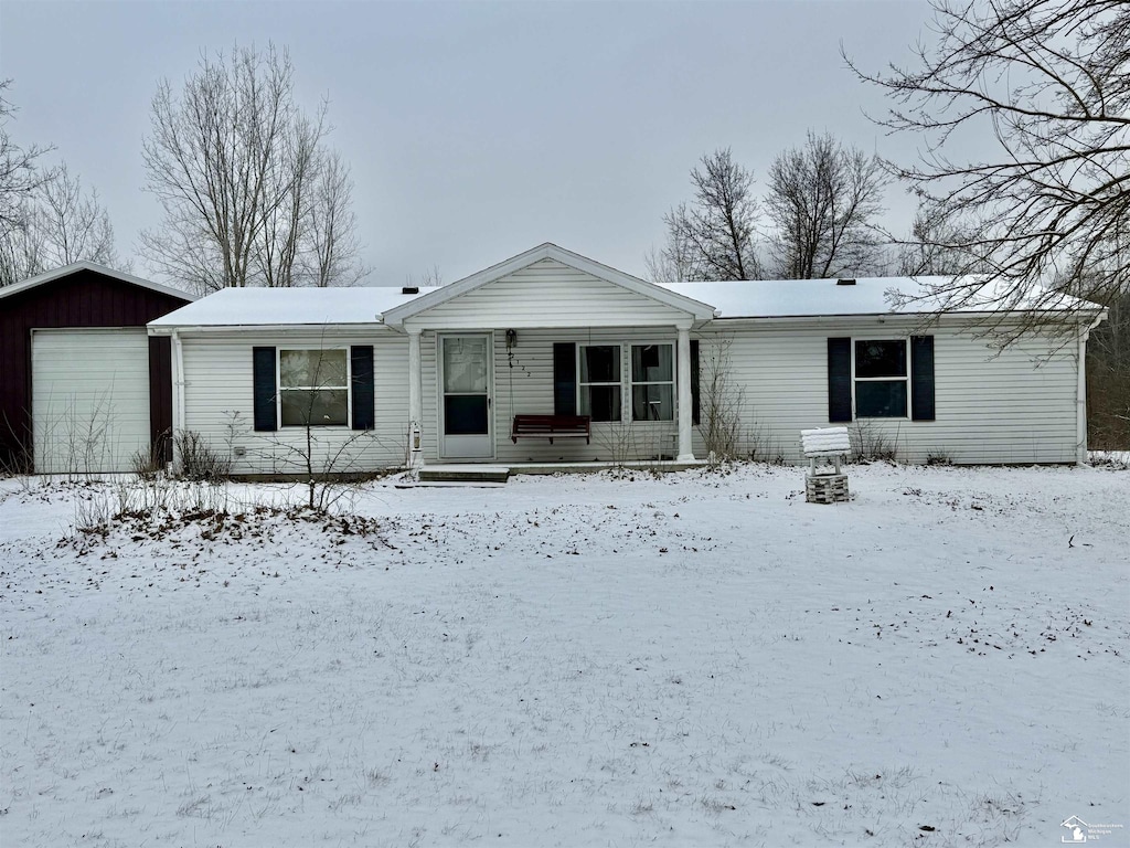 ranch-style home with an outbuilding, a porch, and a garage