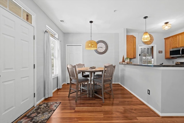 dining space with dark wood-type flooring