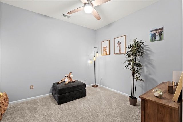 living area with ceiling fan and light colored carpet