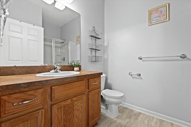 bathroom featuring an enclosed shower, vanity, and toilet