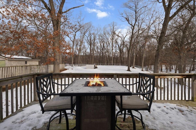 snow covered deck featuring an outdoor fire pit