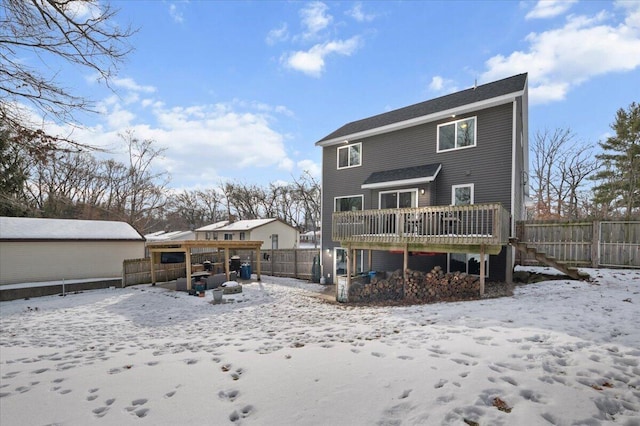 snow covered back of property with a deck