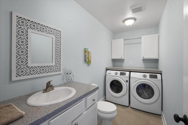 clothes washing area with separate washer and dryer and sink