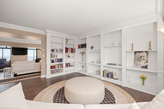 living room with dark wood-type flooring and crown molding