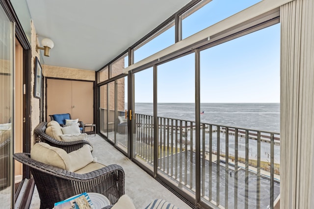 sunroom featuring a water view and a view of the beach