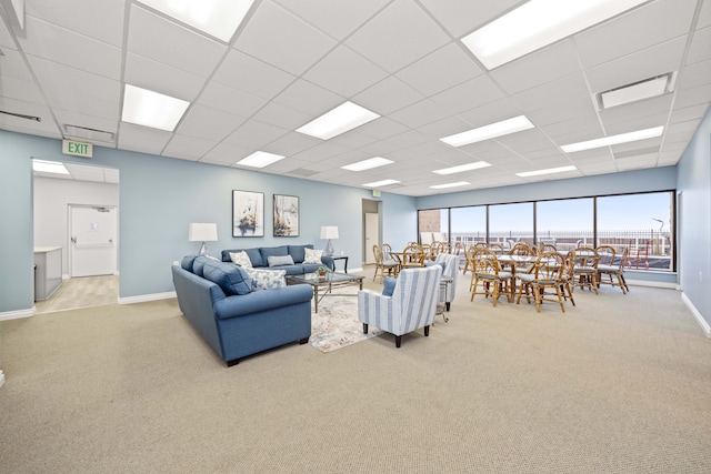 living room featuring light carpet and a drop ceiling