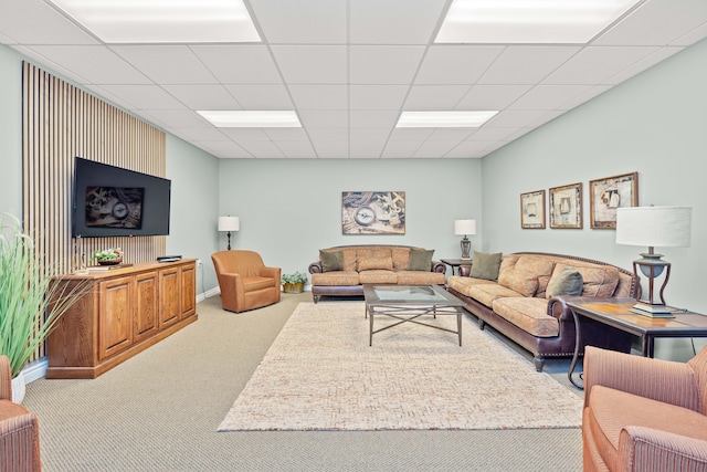 living room with a paneled ceiling and light carpet