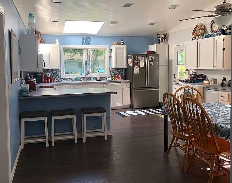 kitchen featuring appliances with stainless steel finishes, sink, white cabinets, and a kitchen breakfast bar