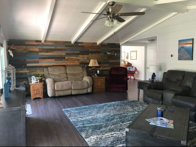 living room with dark wood-type flooring, vaulted ceiling with beams, wood walls, and ceiling fan
