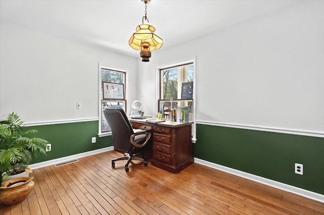 home office with visible vents, baseboards, and hardwood / wood-style floors