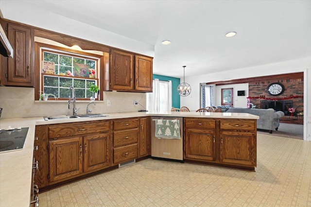 kitchen featuring a chandelier, sink, decorative light fixtures, stainless steel dishwasher, and kitchen peninsula