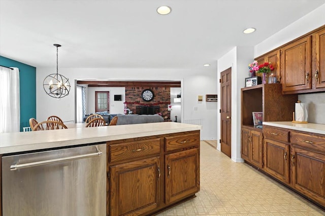 kitchen with a fireplace, a chandelier, hanging light fixtures, and dishwasher