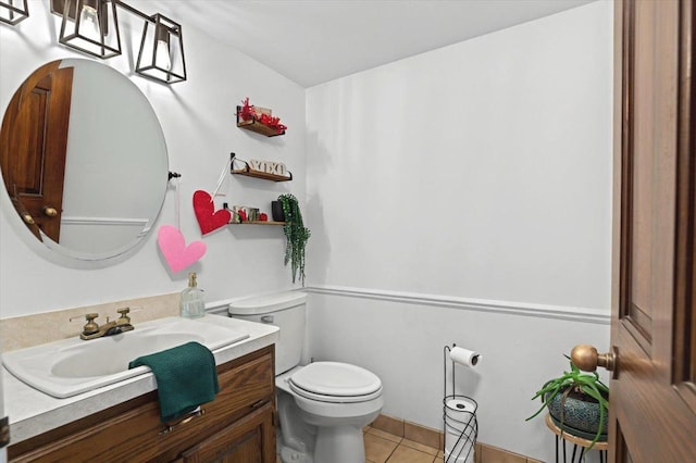 bathroom featuring toilet, vanity, and tile patterned flooring