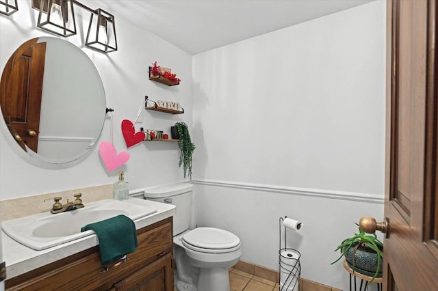 half bath featuring tile patterned flooring, toilet, and vanity