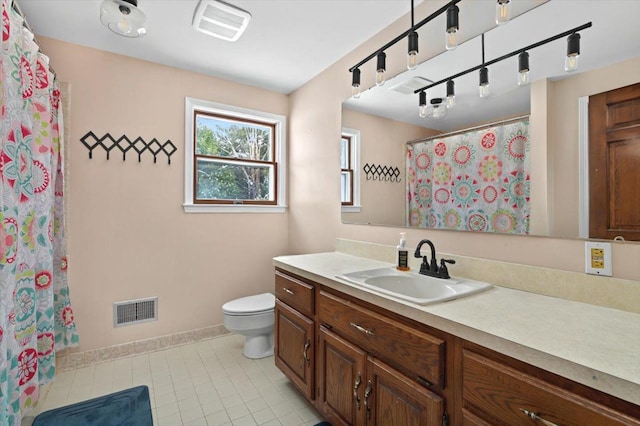 bathroom featuring toilet, vanity, baseboards, and visible vents