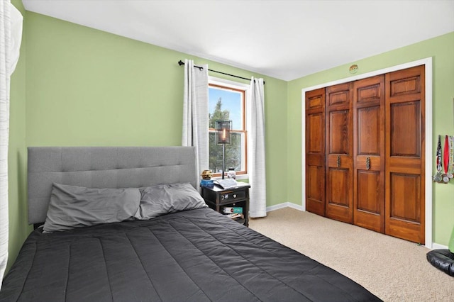 bedroom with a closet, baseboards, and carpet flooring
