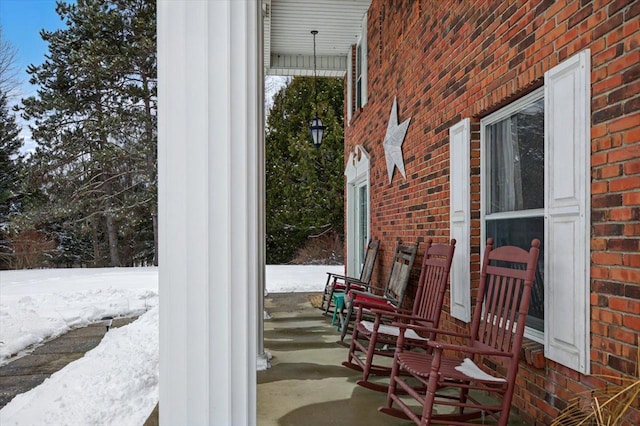 snow covered patio featuring a porch