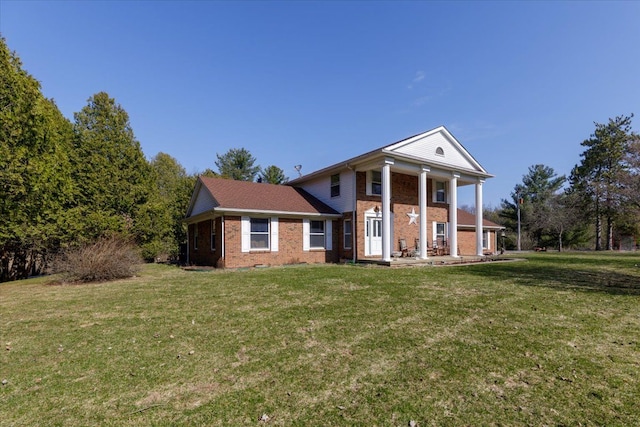 neoclassical / greek revival house with brick siding and a front yard