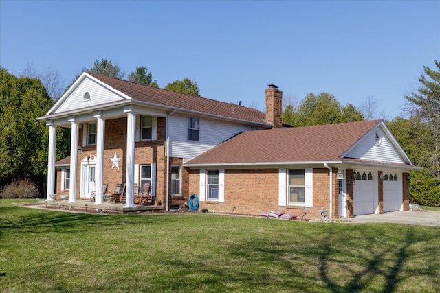 neoclassical / greek revival house featuring brick siding, a front lawn, a chimney, and an attached garage