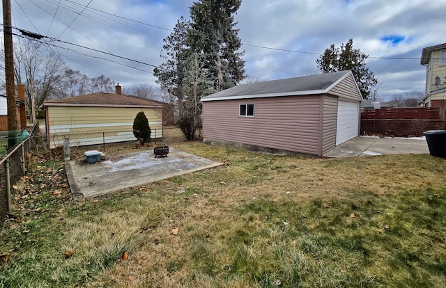 view of yard featuring an outdoor fire pit, an outdoor structure, and a garage