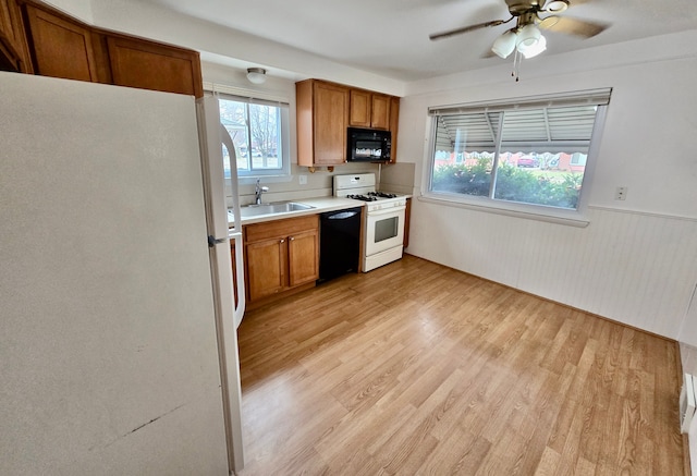 kitchen featuring sink, black appliances, light hardwood / wood-style floors, and ceiling fan