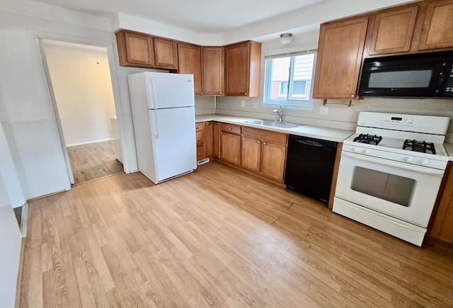 kitchen featuring sink, light wood-type flooring, and black appliances