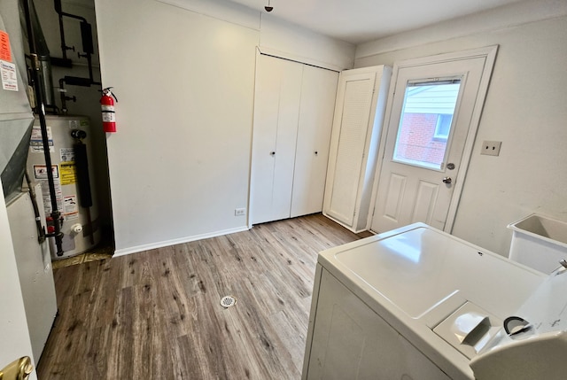 washroom featuring washer and dryer, light hardwood / wood-style flooring, and water heater