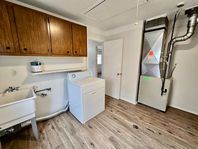 laundry area featuring washer / clothes dryer, cabinets, and light wood-type flooring