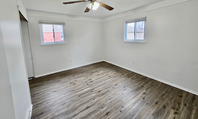 unfurnished room with dark hardwood / wood-style floors, a wealth of natural light, and ceiling fan