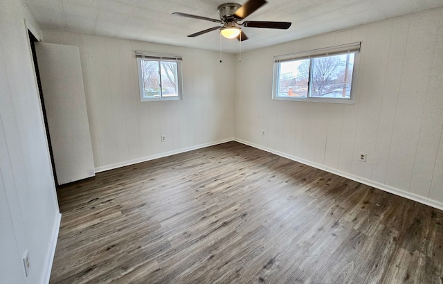 empty room with dark wood-type flooring and ceiling fan