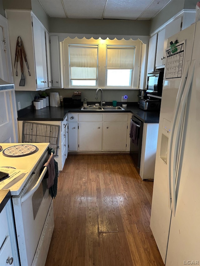 kitchen featuring white cabinetry, white appliances, wood-type flooring, and sink