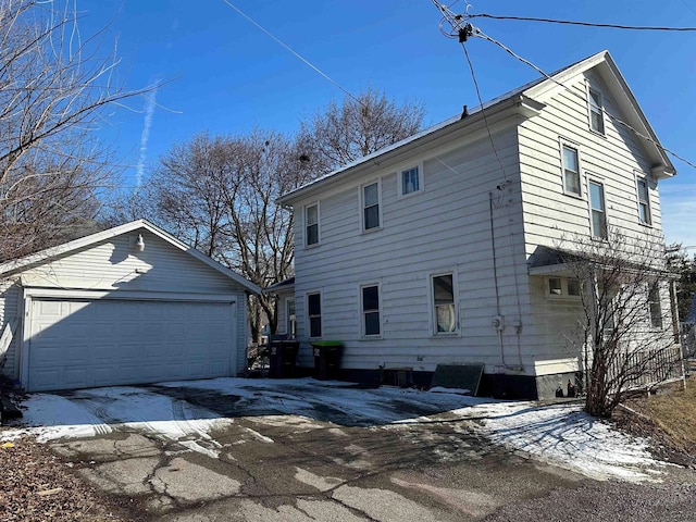 snow covered property with an outbuilding and a garage