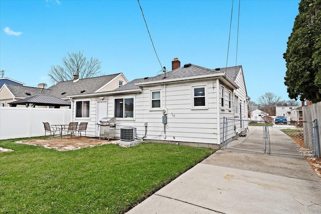 back of property with a yard, a patio, and central air condition unit